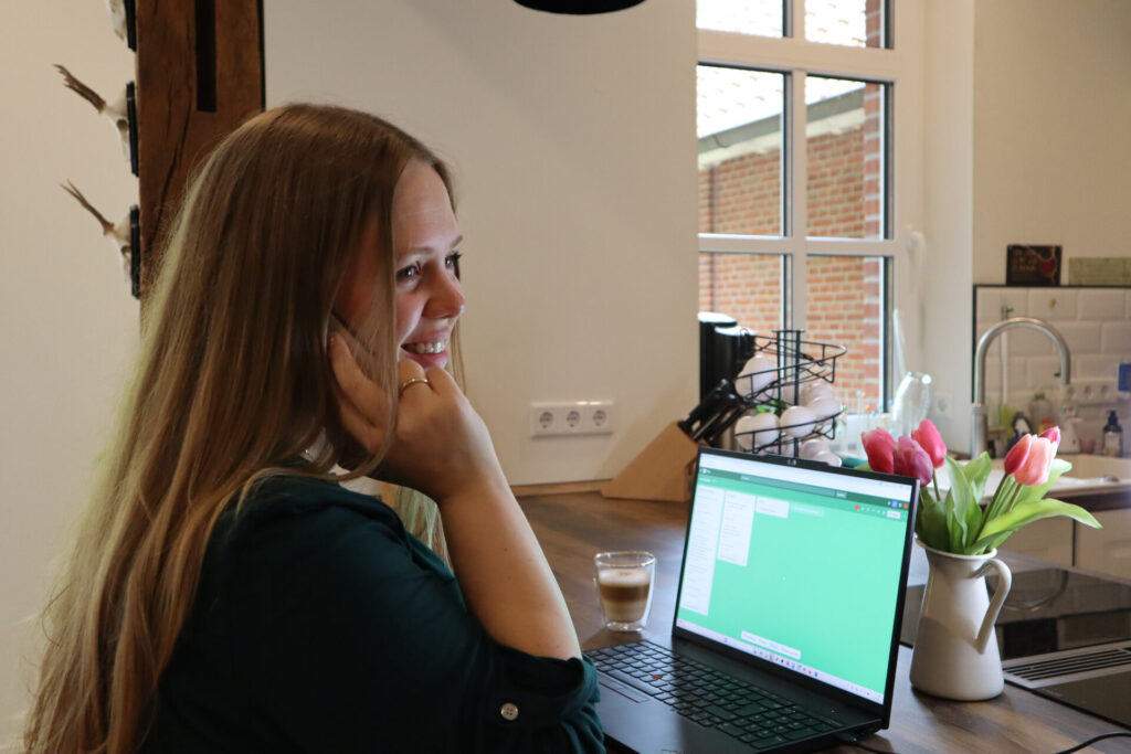 Johanna von Dincklage sitzt telefonierend vor dem Laptop und organisiert das Coaching