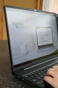 Aufgeklappter Laptop, Hände auf der Tastatur, der Bildschirm zeigt die Agenda des 1:1 Coachings